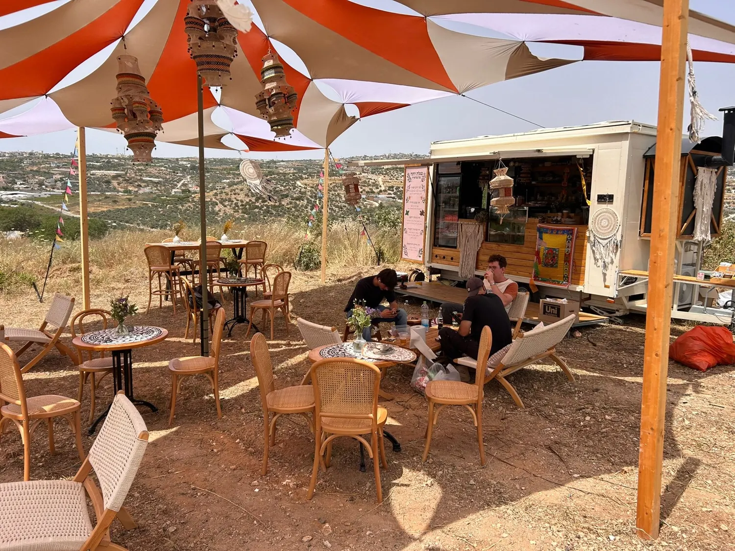 החיים הם תקופה קשה · מבט רחב: מפרשי צל מפוספסים, כיסאות קש והעגלה